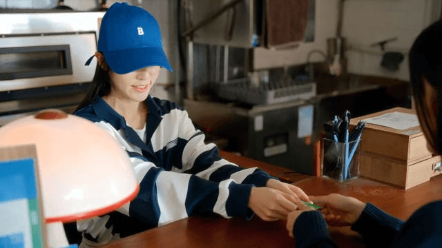 Woman handing over a card and an employee making payment
