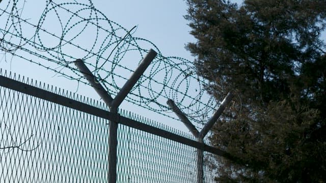 Sharp Barbed Wire Wrapped Around a Fence