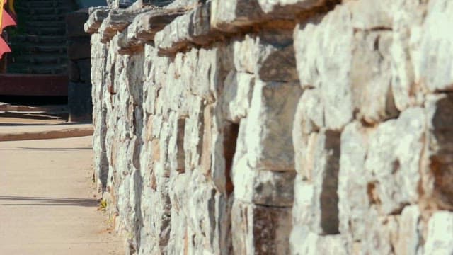 Traditional Stone Wall and Flapping Colorful Flags