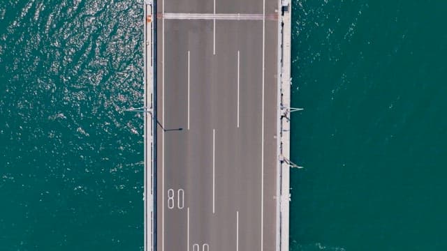 Bridge with cars passing over the vast emerald sea