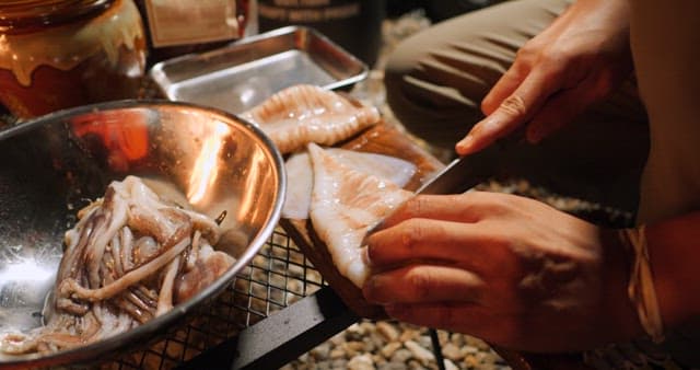 Preparing Squid on an Outdoor Grill at Night