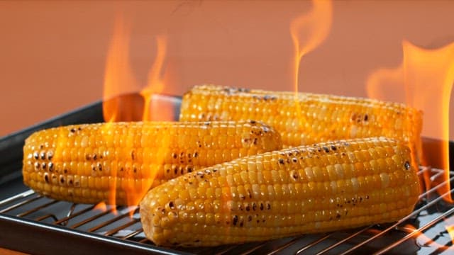 Corn being roasted with flames
