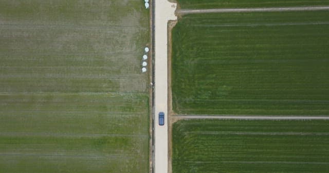 Car driving through vast green fields