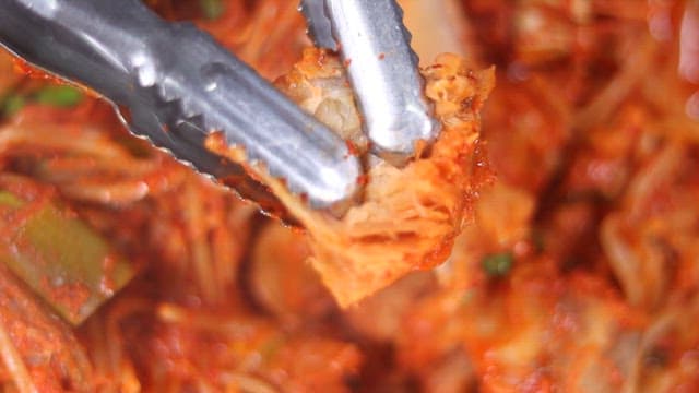 Tearing up a delicious and spicy Agujjim with tongs