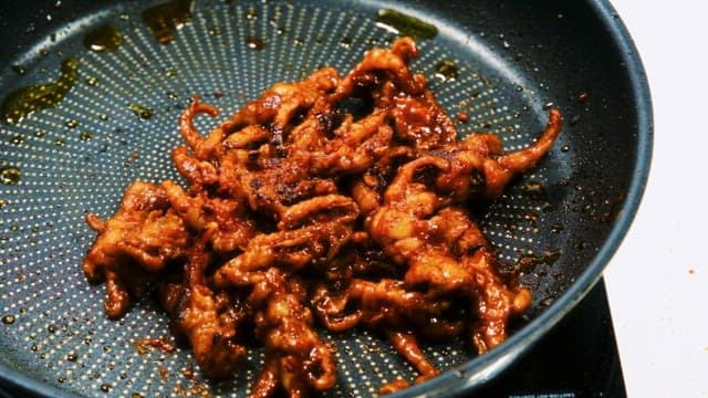 Stir-Fried Chicken Feet Cooking in a Frying Pan