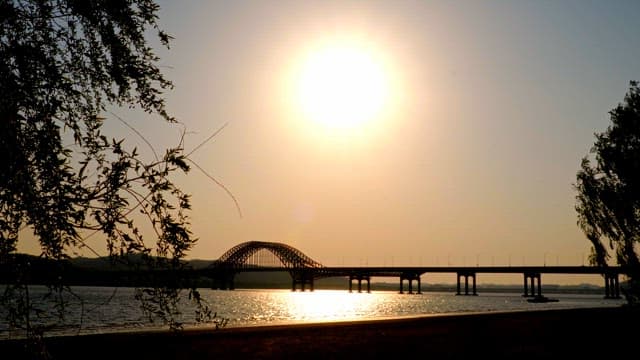 Sunset over a bridge by the river