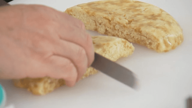 Slicing a freshly baked pancake on a cutting board
