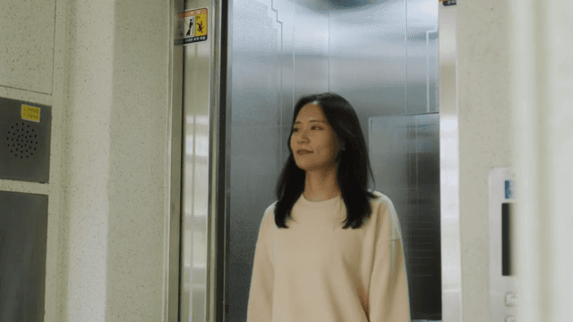 Woman getting out of the elevator in an apartment building