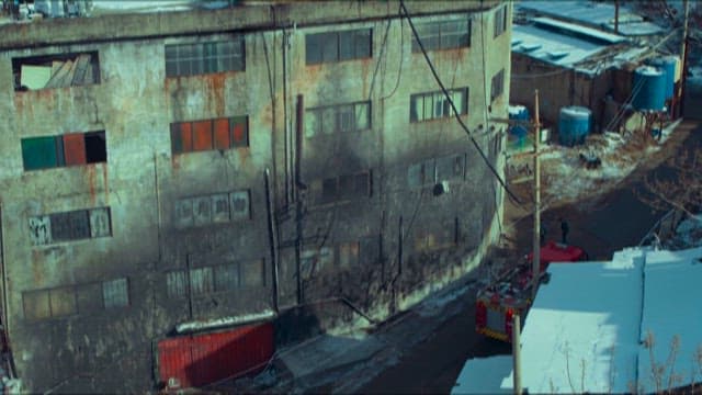 Fire trucks outside a smoke-damaged building in winter