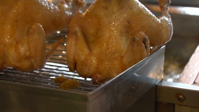 Freshly fried chicken on metal rack