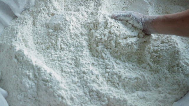 Hand mixing flour in a large container
