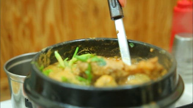 Picking up duck meat from duck soup with chopsticks