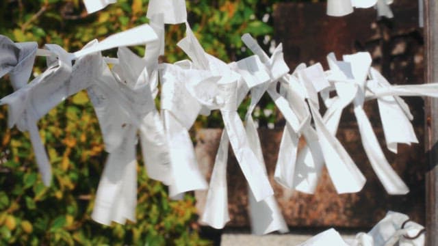 White wish paper strips tied on a string in a temple