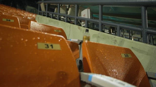 Empty stadium seats with drink bottles left behind