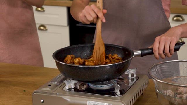 Stir Seasoned Octopus in a Pan on a Burner