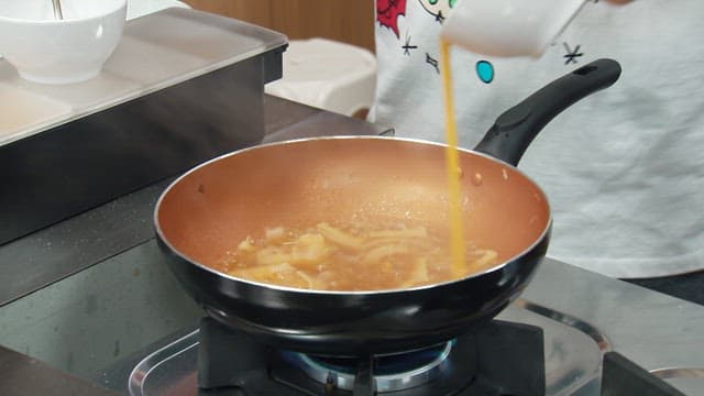 Egg being poured into a boiling pot
