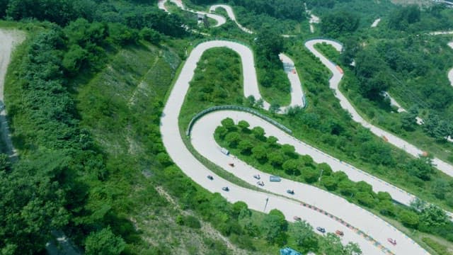 Luges Running on a Winding Track Built on a Mountainside