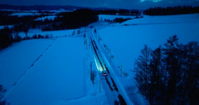 Snowscape with Passing Car in the Evening