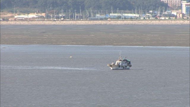 Fishing boat on a tidal flat where the tide is receding