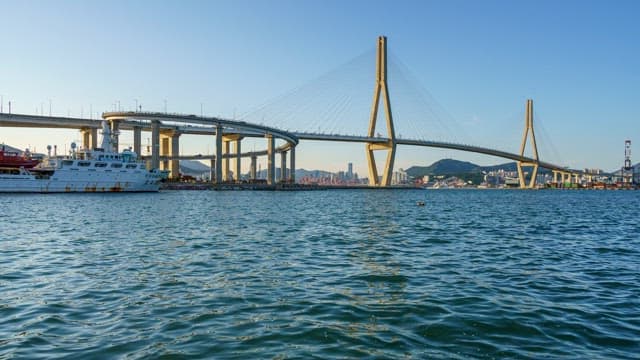 Busan Port Bridge and the seaport with ships anchored on a clear afternoon
