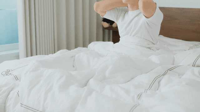 Man waking up and checking phone in bed