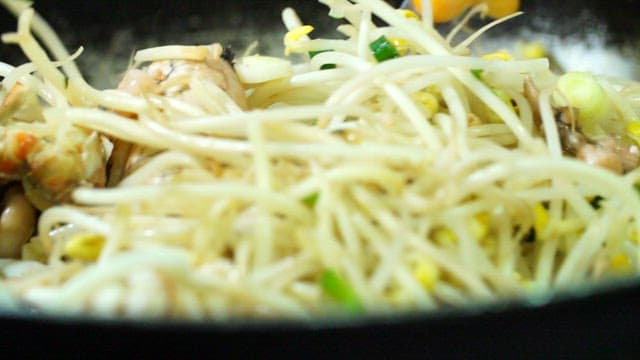 Cooking seafood with bean sprouts in a pan