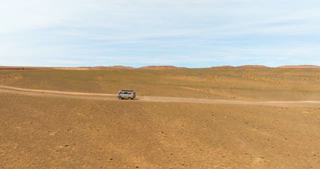 Van traveling through a vast desert