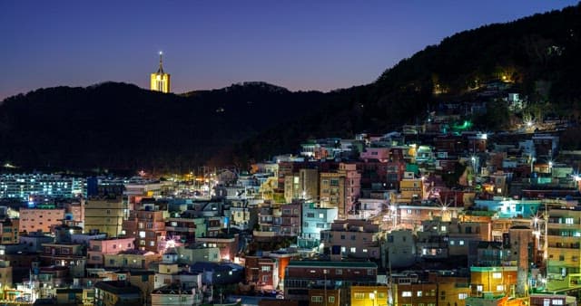 Night sky and night view of a hillside neighborhood with dense buildings