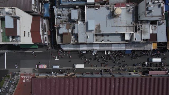Street Crowded with People Between Buildings 