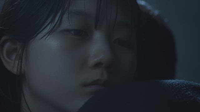 Girl sleeping on someone else's shoulder in the dark