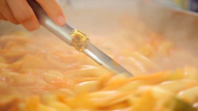 Stirring boiling spicy tteokbokki with a ladle