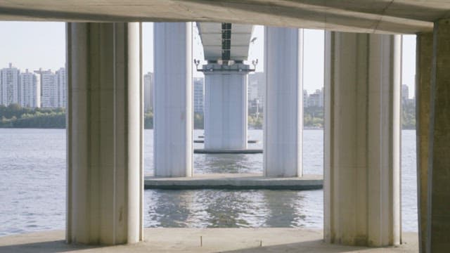 Cityscape Seen Beyond Symmetrical Bridge Pillars