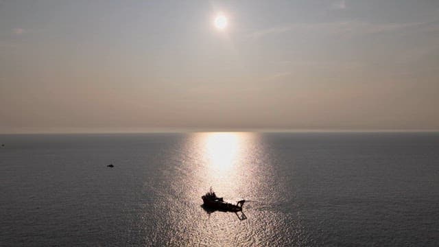 Ship sailing on the calm sea at sunset