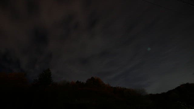 Night sky transitioning to dawn over hills