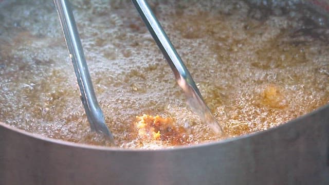 Fried chicken being cooked in hot oil