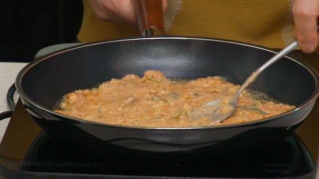 Cooking kimchi pancakes in a hot oiled frying pan