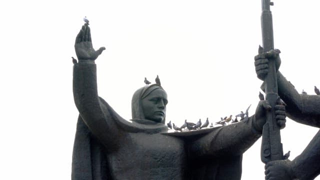 Pigeons perched on a large statue in the city