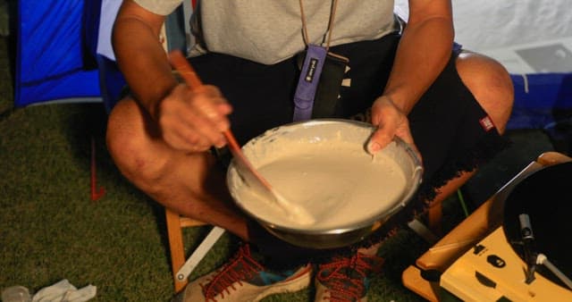 Man Preparing Batter in Outdoor Setting