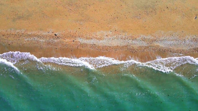 Secluded beach with emerald waves crashing in