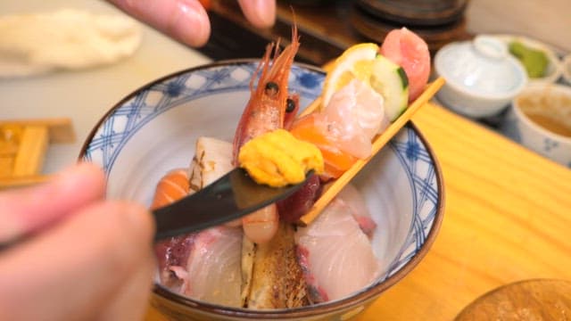 Plate of colorful seafood including shrimp, sashimi, and roe