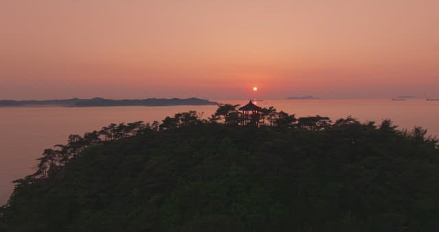 Sunset over a calm sea with distant mountain