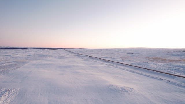 Vast snowy landscape with a long road