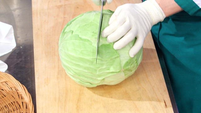 Cutting a fresh cabbage on a wooden board