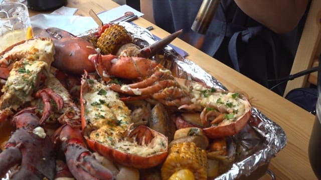 Person who melts cheese on lobster with a torch