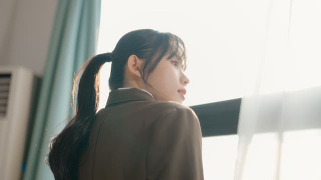 Student looking out the window with sunlight