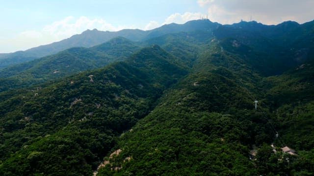 Lush green mountains with distant buildings