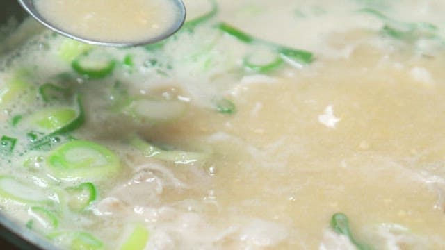 Pork soup with green onions boiling in a pot