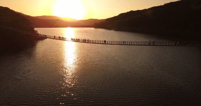 People walking on a bridge at sunset