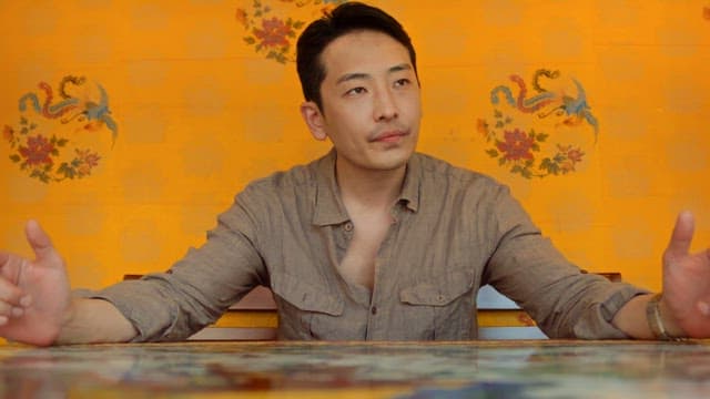 Man sitting at a table with a yellow wall