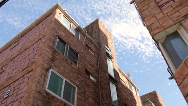 Red Brick Apartment Building Against Blue Sky